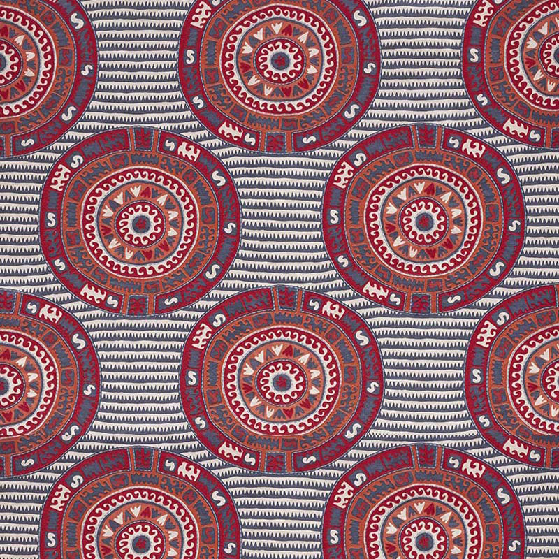 Bold circular mandala motifs in red, blue and white on a navy striped background.