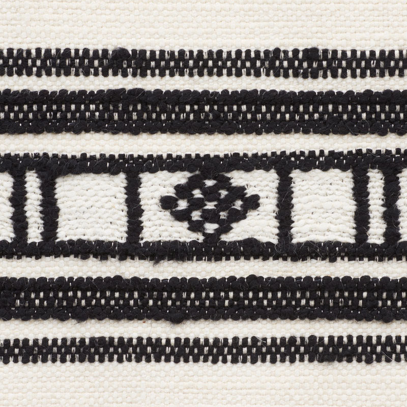 Close-up of black and white patterned woven fabric with a geometric lattice and diamond motif.