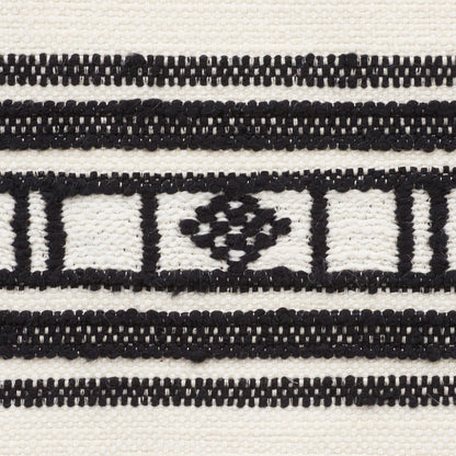Close-up of black and white patterned woven fabric with a geometric lattice and diamond motif.