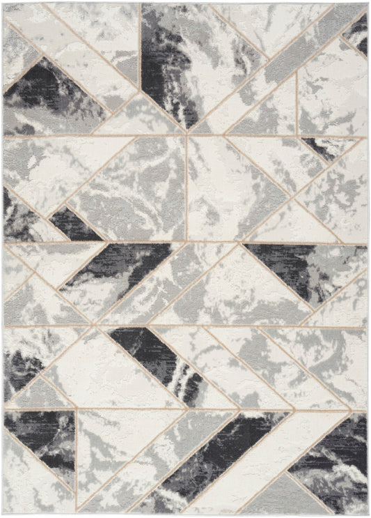 Geometric triangle patchwork rug in grayscale with beige seam lines; modern abstract style.