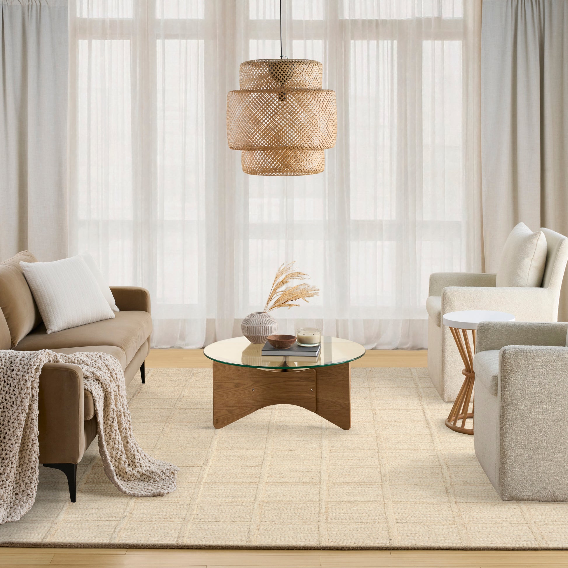 Neutral modern rug on the floor in a living room setting with beige sofa and armchairs.