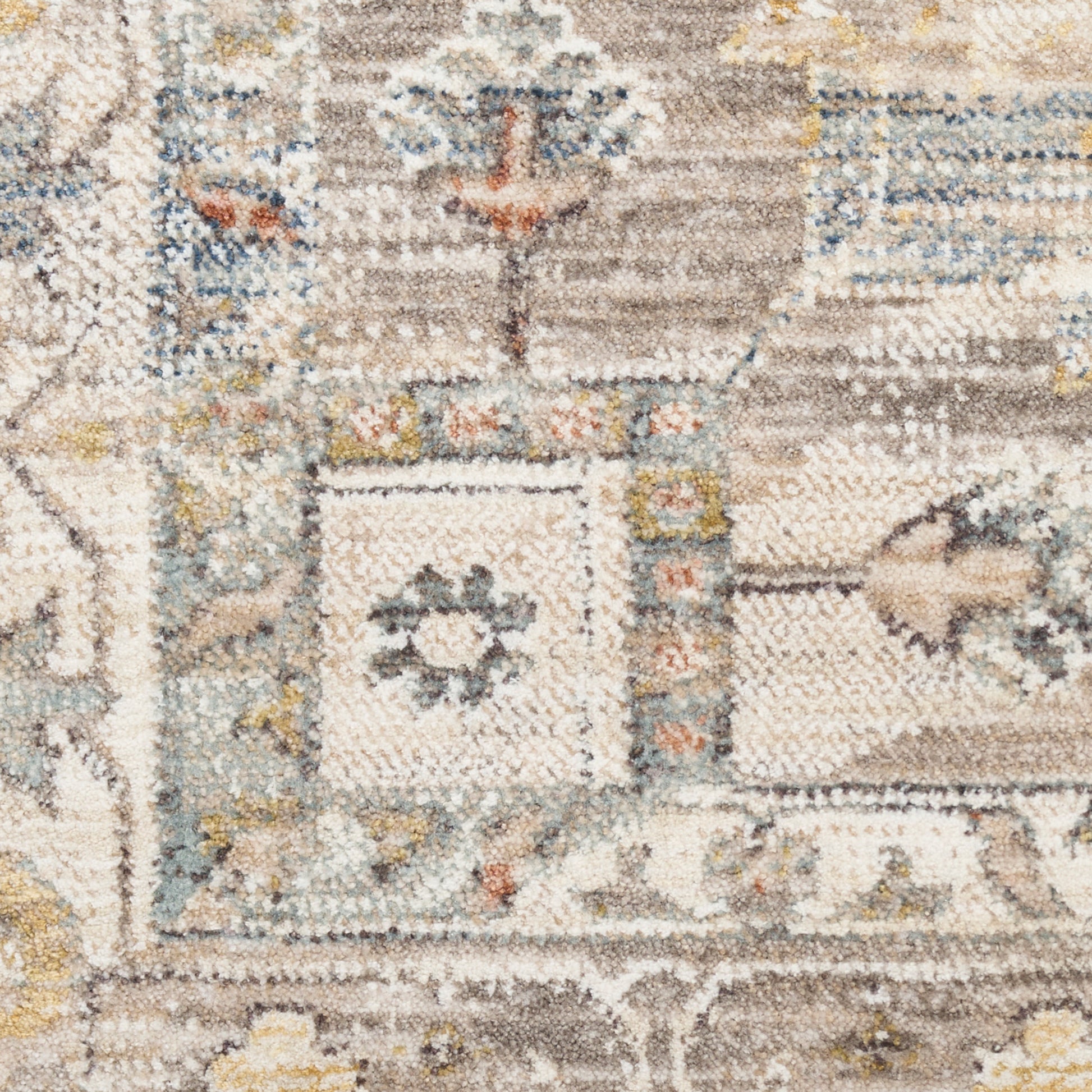 Close-up of a plush oriental rug with cream, taupe, blue and yellow geometric motifs.