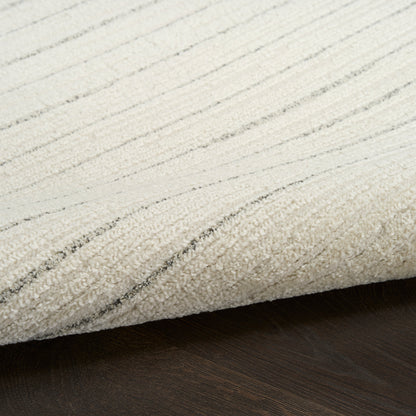 Cream rug with soft texture and subtle gray stripes, partially rolled on a dark wood floor.