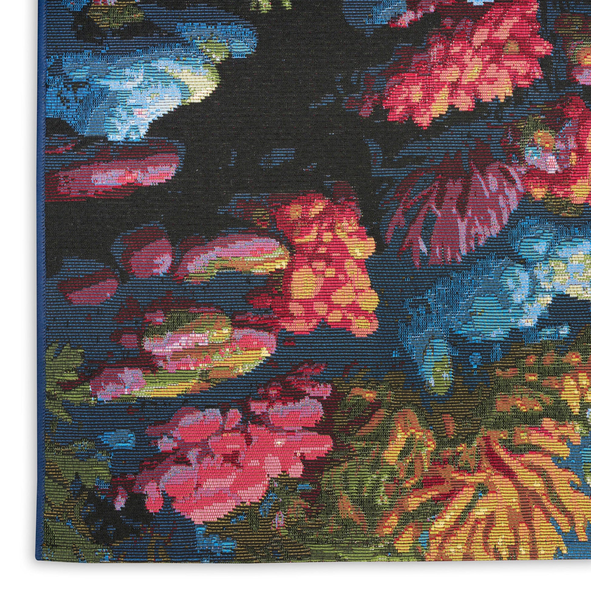 Vivid floral rug with a dark navy background; woven rug featuring pink, red, yellow blooms and blue-green accents