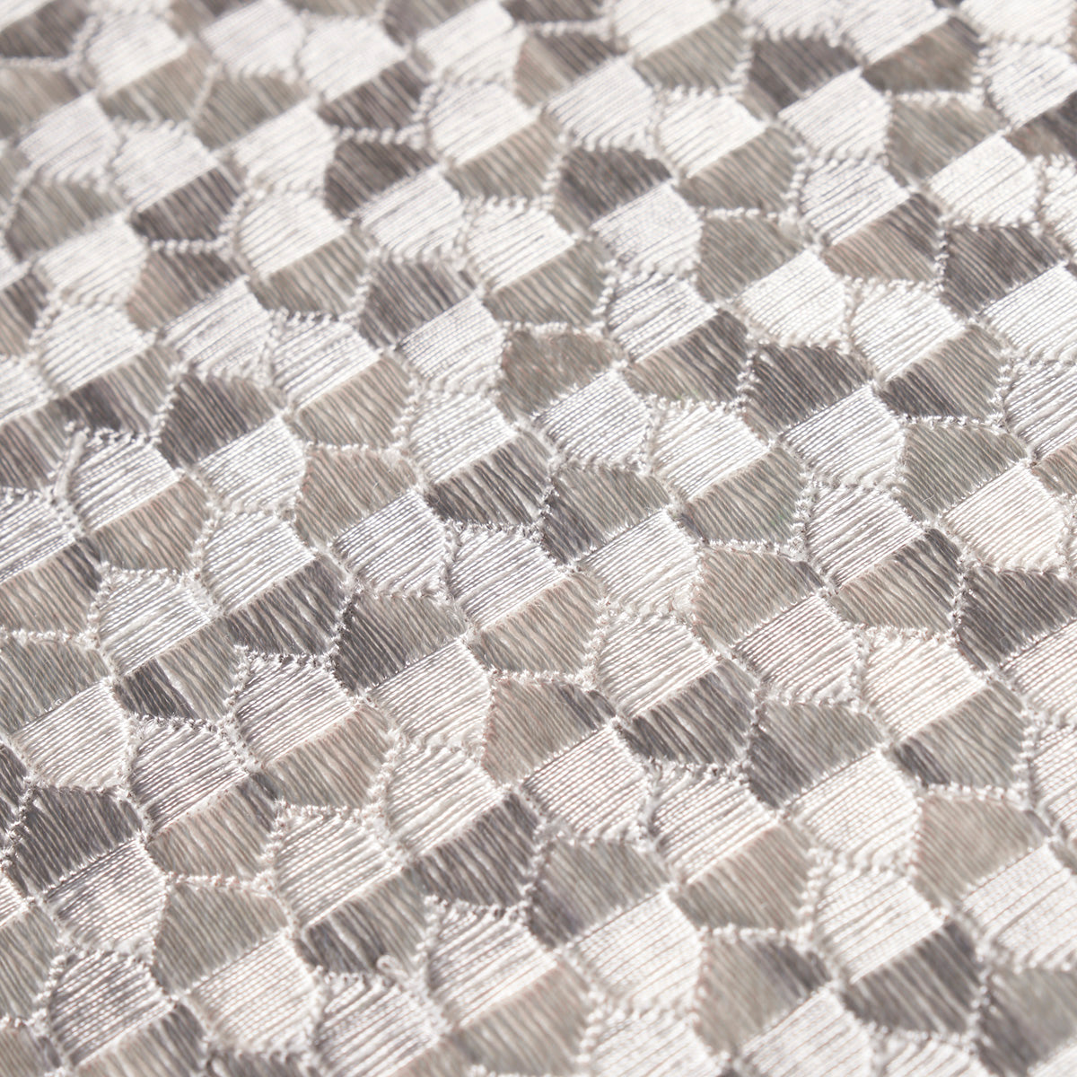 Gray metallic woven fabric with a tessellated diamond pattern; glossy, textured textile suitable for upholstery or fashion.