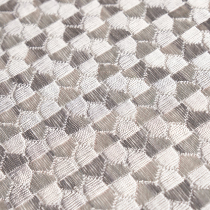 Gray metallic woven fabric with a tessellated diamond pattern; glossy, textured textile suitable for upholstery or fashion.