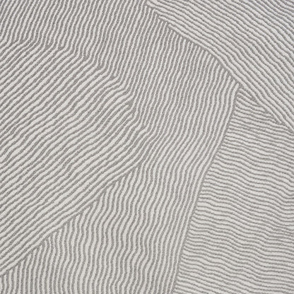 Close-up of light gray-beige patterned woven fabric with raised parallel ribs and a patchwork seam.