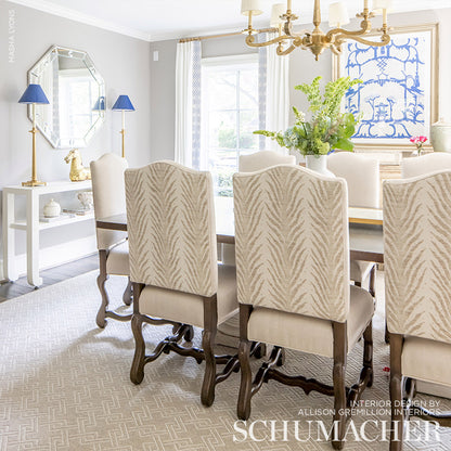 Beige woven upholstery fabric in a Creeping Fern pattern (Dune) used on chairs around a table.