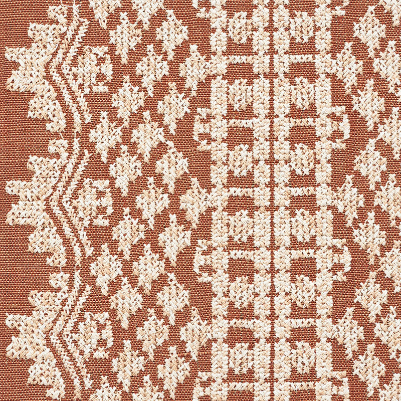 Rust-red woven rug with ivory geometric floral pattern; traditional kilim-inspired textile.