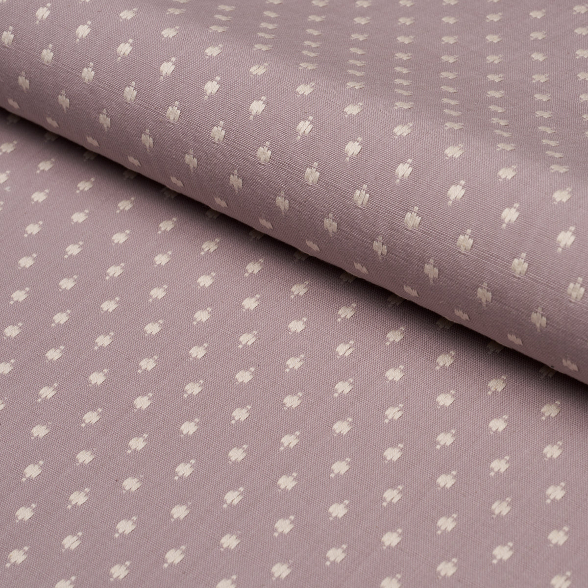 Rolled lavender fabric with tiny white floral motifs in a soft cotton-like weave.