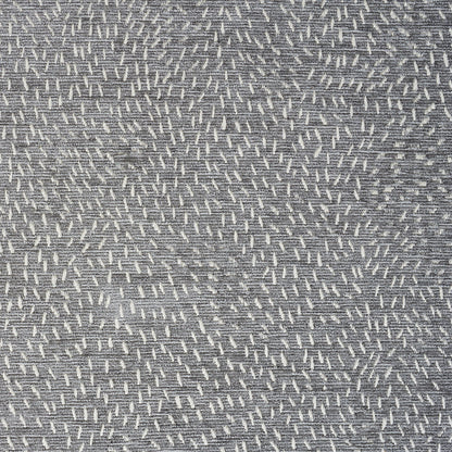 Grey woven fabric with small white dash stitches forming a speckled diagonal pattern; soft upholstery textile.