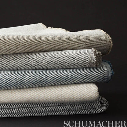 Stack of folded charcoal twill fabric with frayed edges.