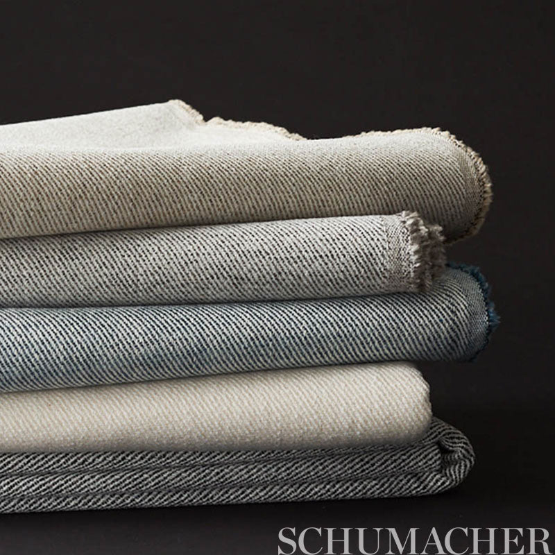 Stack of folded denim-style twill fabrics in beige, taupe, gray, blue & charcoal; textured cotton.