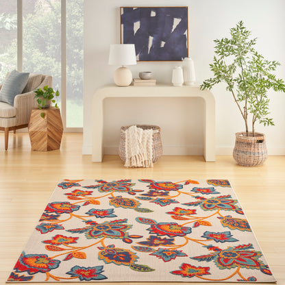 Bright living room with a colorful floral area rug; light background, cream console, and lush potted plant.