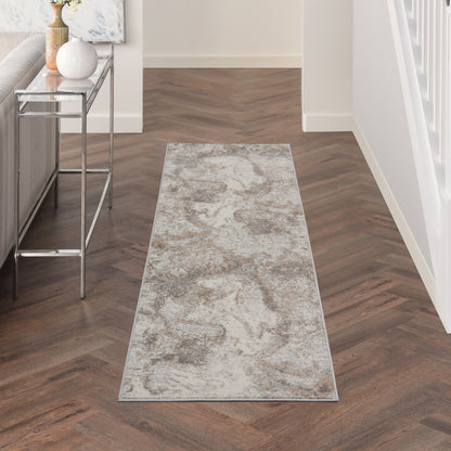 Rectangular gray-beige marble-pattern hallway rug on dark herringbone floor & chrome-glass console nearby.