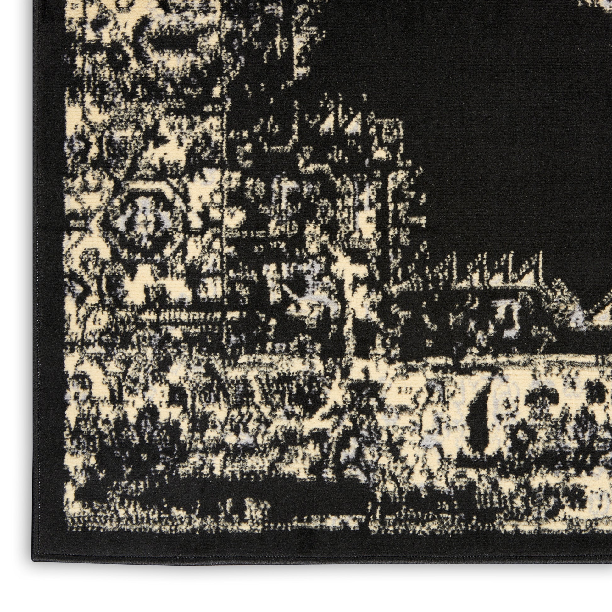Black and ivory distressed oriental-style runner rug with an intricate border.
