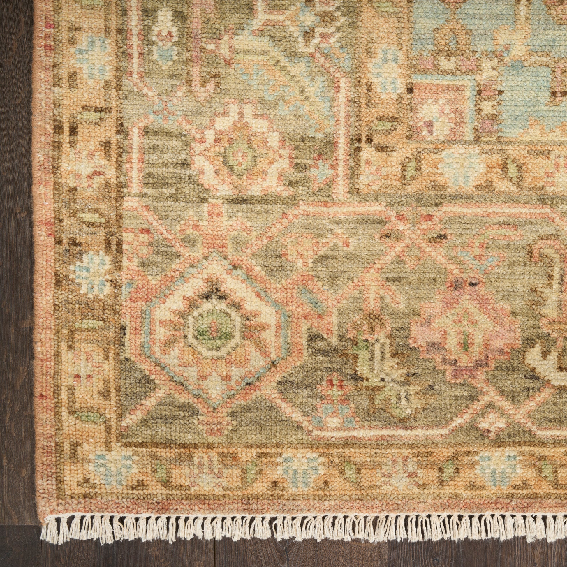 Close-up of fringed oriental vintage rug with brown border and muted geometric patterns in beige, teal, pink, and olive, 9' x 12'.
