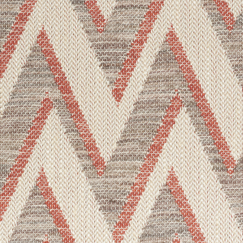 Woven rug with cream base and rust red/gray chevron triangles; textured, rustic tribal style.