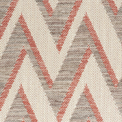 Woven rug with cream base and rust red/gray chevron triangles; textured, rustic tribal style.