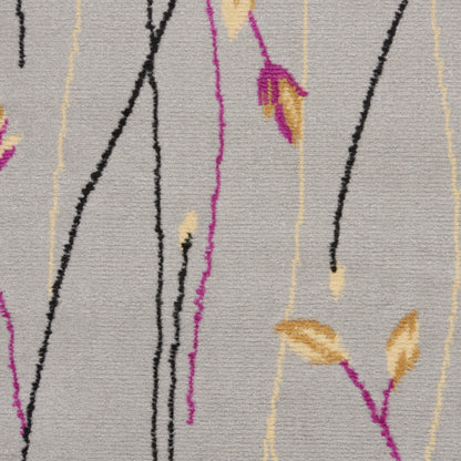 Woven beige rug with abstract black and magenta lines and yellow-brown leaf motifs; contemporary botanical design.