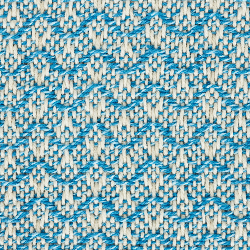 Close-up of woven fabric with blue chevron zigzag pattern on cream background.