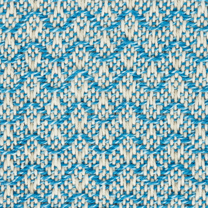 Close-up of woven fabric with blue chevron zigzag pattern on cream background.