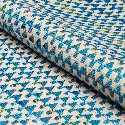 Rolled woven textile with blue geometric pattern on ivory base; teal, yellow and red specks; upholstery swatch.
