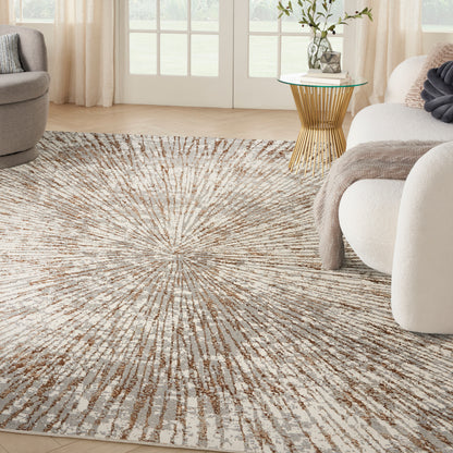 Plush beige cream sunburst area rug in a bright living room with gold glass-top side table and neutral seating.