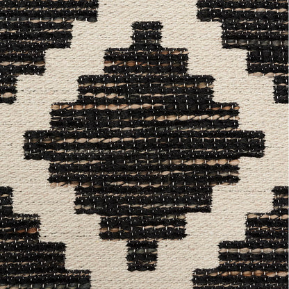 Woven rectangular area rug with black geometric diamond motifs on natural beige background; tribal pattern.