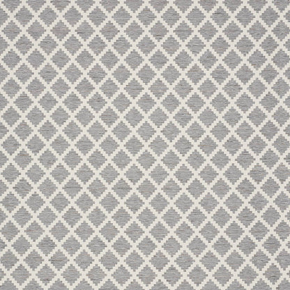 Grey & white diamond lattice rug with a textured woven surface & neutral modern geometric pattern.