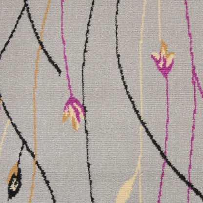 Beige woven rug with abstract black, magenta and pale yellow vertical lines and small leaf accents.
