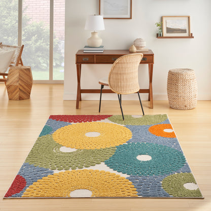 Colorful area rug with large yellow, teal and orange circular patterns on a blue background in a bright home office.