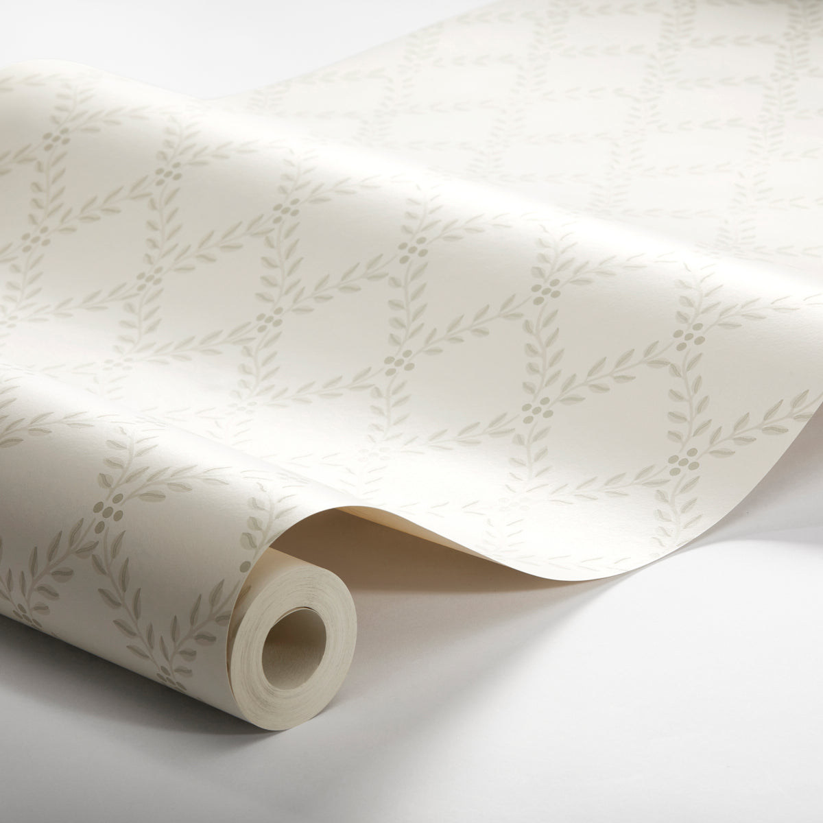 Ivory wallpaper with delicate light-grey leafy garland pattern, rolled up.