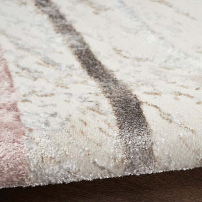 Close-up of cream shag rug with blush pink and charcoal stripes and soft, textured pile.