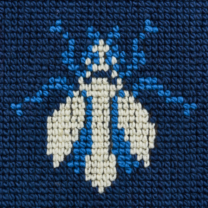 Navy velvet fabric close-up featuring a cream and light-blue geometric diamond motif.