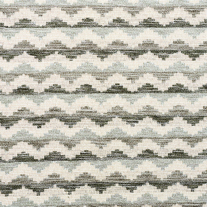 Knitted fabric with repeating gray and white chevron zigzag pattern; soft, cozy textile for sweaters or scarves.