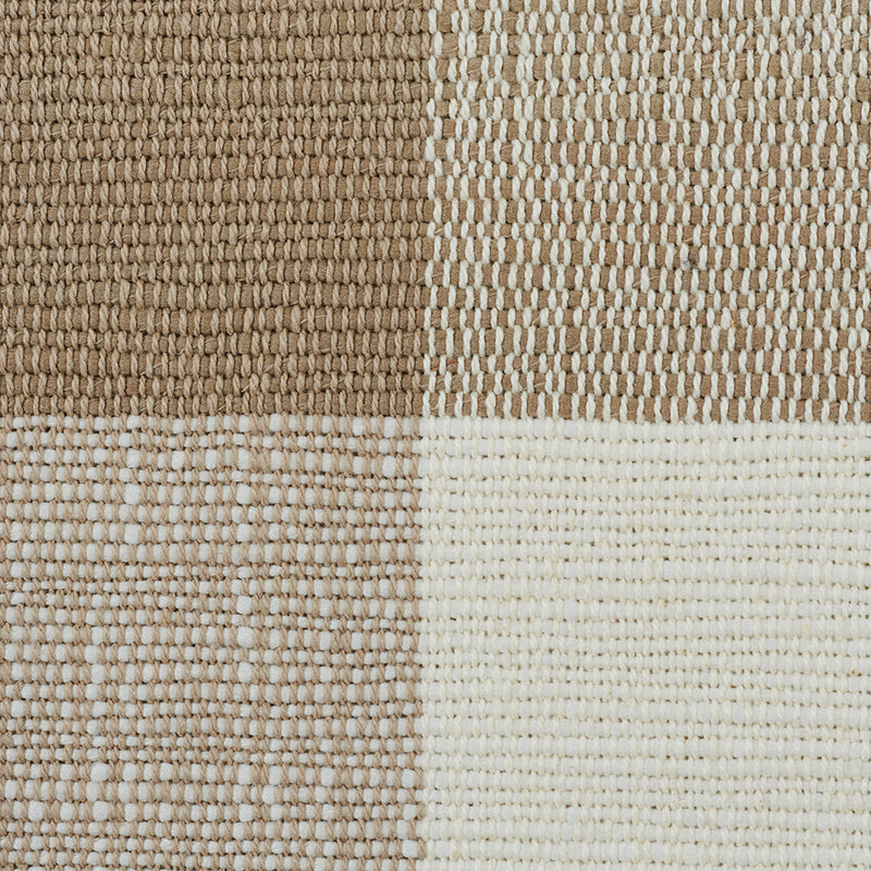 Patterned woven rug with a check design in dark brown, tan, beige, and cream.