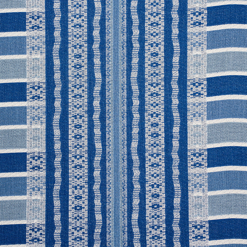 Blue and white woven textile with vertical striped bands and geometric motifs, beach towel style.