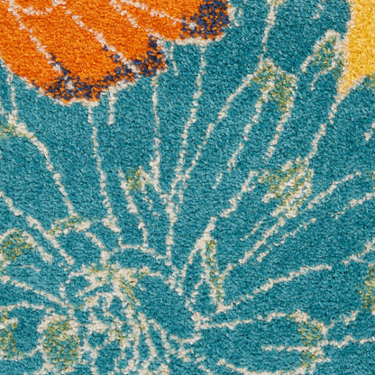 Boho shag rug in teal with white radiating tie-dye lines, orange corner and yellow accents.