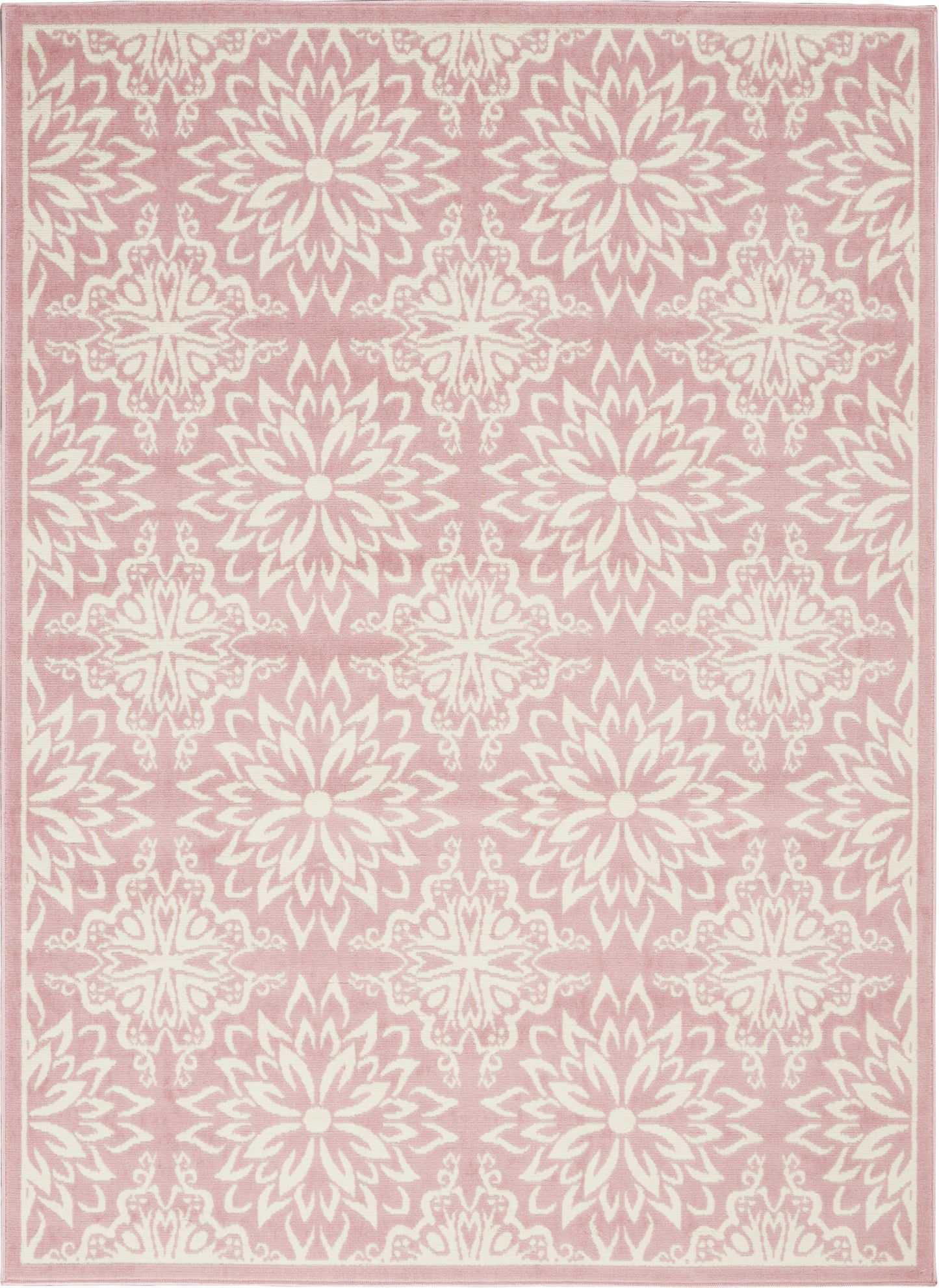 Soft pink area rug with ivory floral medallions, repeating starburst rosettes and pale border trim.