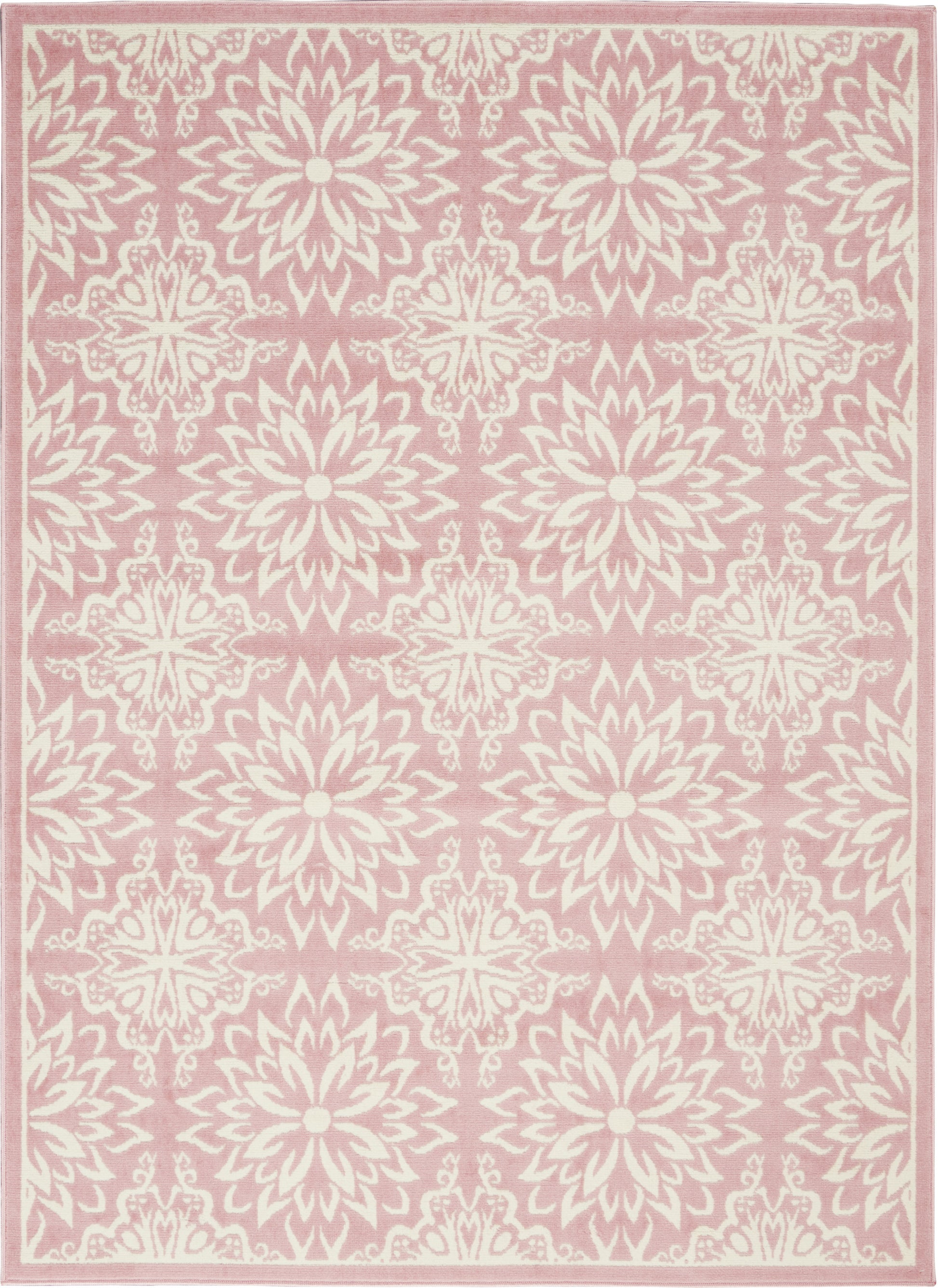 Soft pink area rug with ivory floral medallions, repeating starburst rosettes and pale border trim.