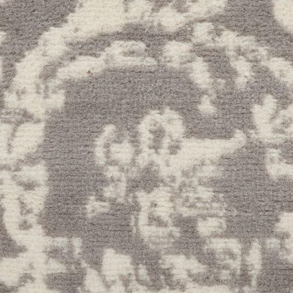 Close-up of a grey rug with ivory abstract pattern and soft, plush pile.
