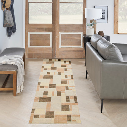 Geometric beige and brown runner rug in a living room entry; gray sofa, wooden doors, bench with throw.