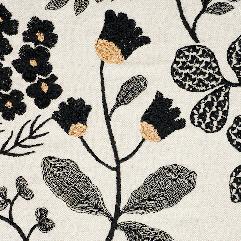 Cream fabric with black embroidered flowers and beige accents; decorative floral textile.