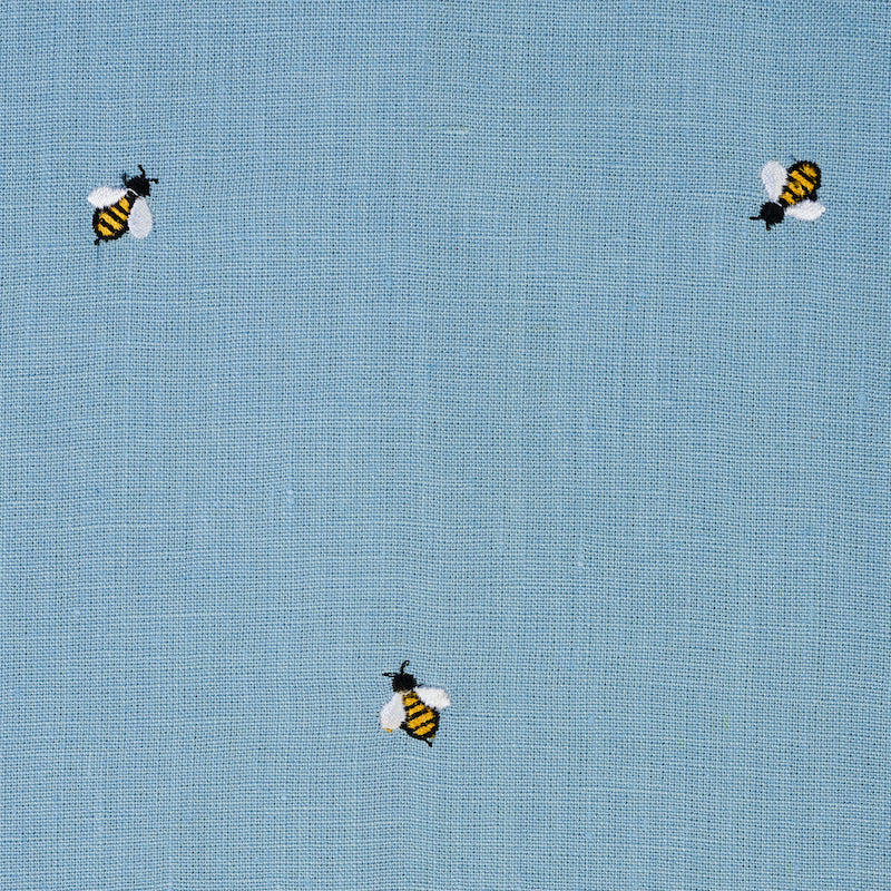 Light blue woven fabric with small embroidered yellow-and-black bees.