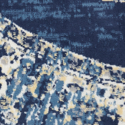 Close-up of a blue abstract rug with navy, teal, cream & pale yellow tones; plush textured pile, modern distressed pattern.