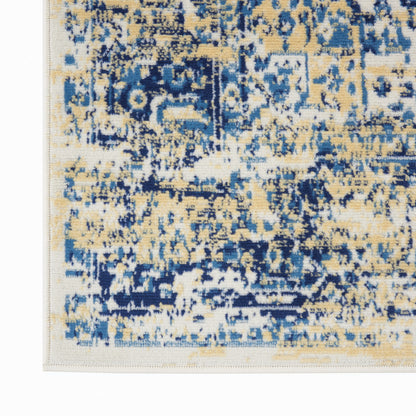 Close-up of an abstract distressed blue and beige area rug corner with a pale border.