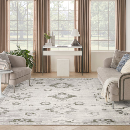 Neutral living room with beige sofas, gray ivory floral rug, white console table, lamp, plant, & tan-curtained windows.