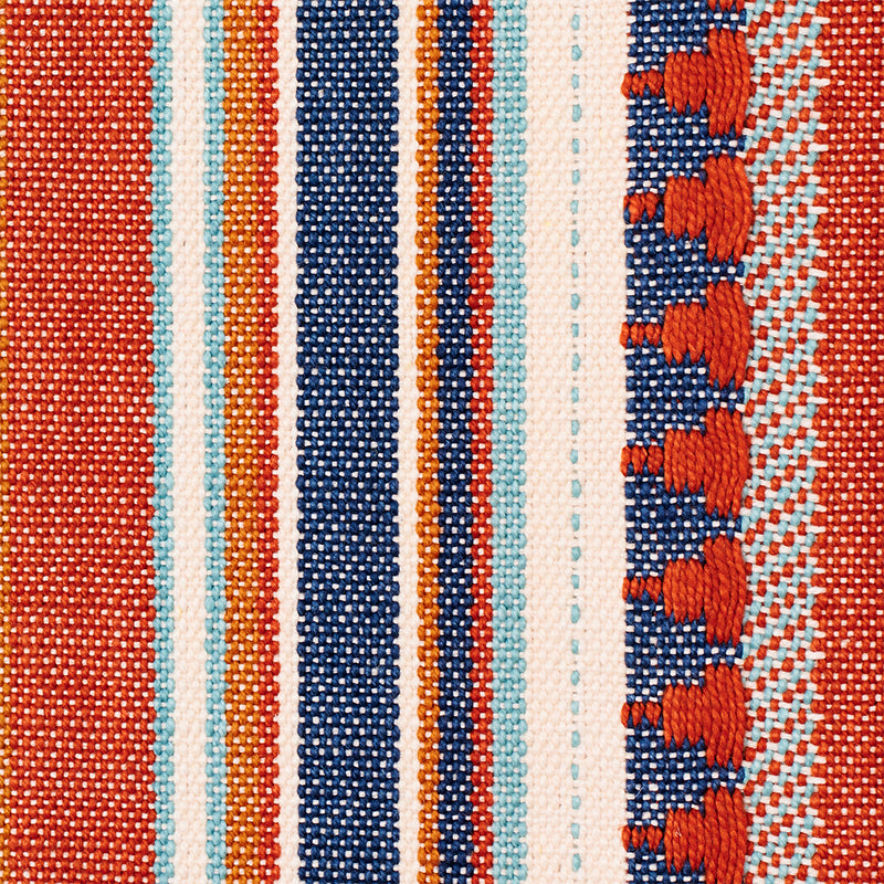 Close-up woven fabric with blue & orange stripes; textured weave and fringe along the right.