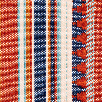 Close-up woven fabric with blue & orange stripes; textured weave and fringe along the right.